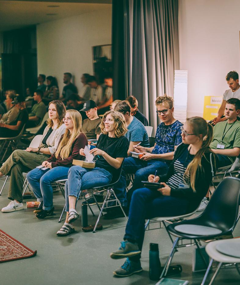 Personen hören bei einem Vortrag zu